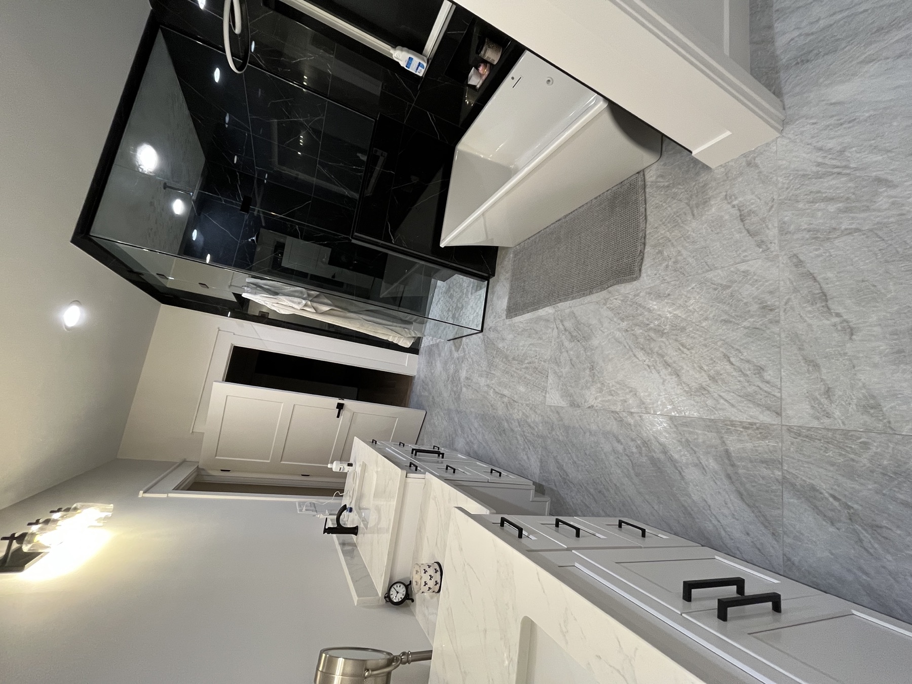 Master bath with double vanity and black marble shower